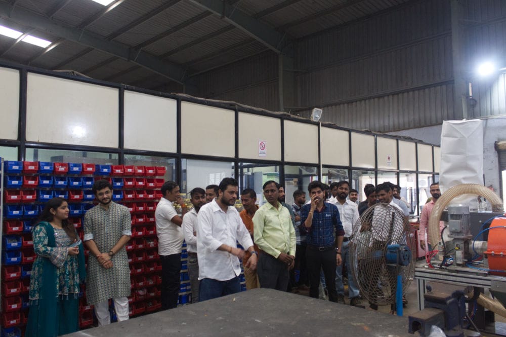 Group of people in a factory setting.