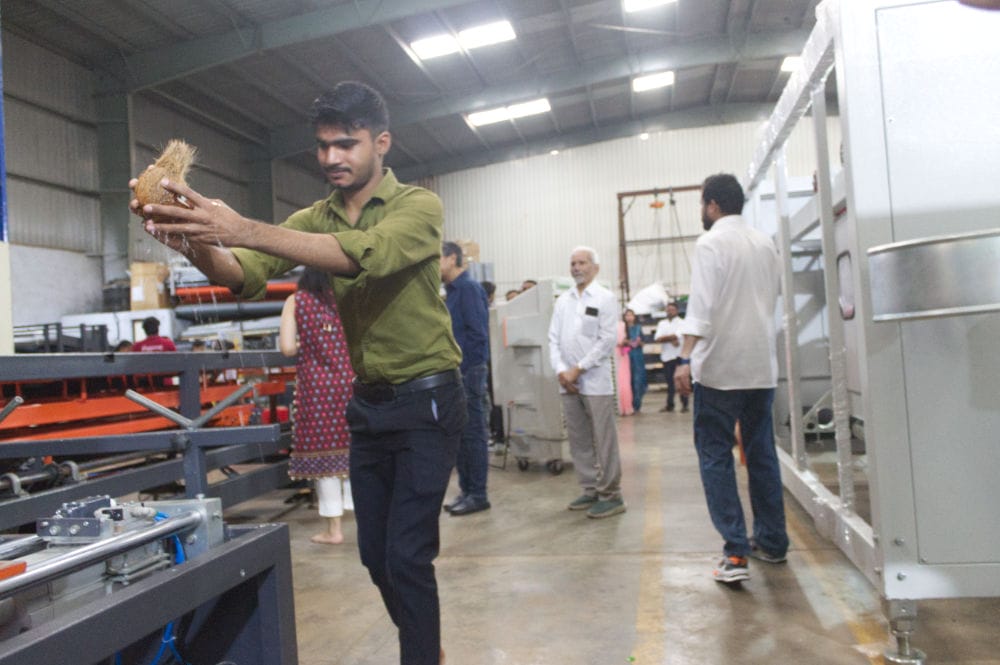 Man holding coconut in busy warehouse