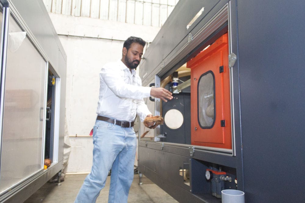 Man operating industrial machinery in factory setting.