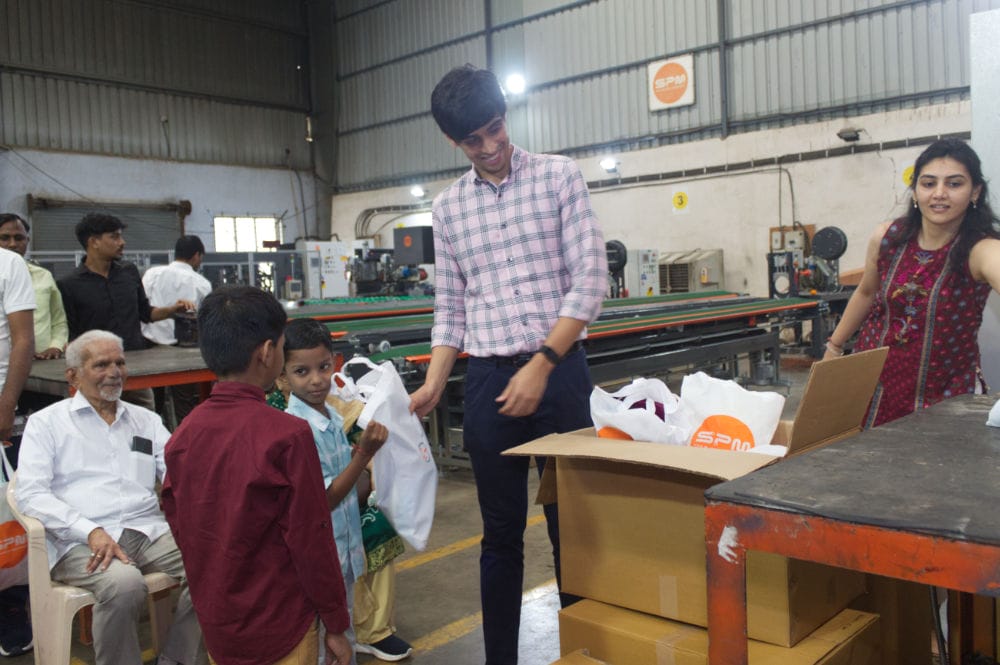 People distributing gifts in a factory setting.