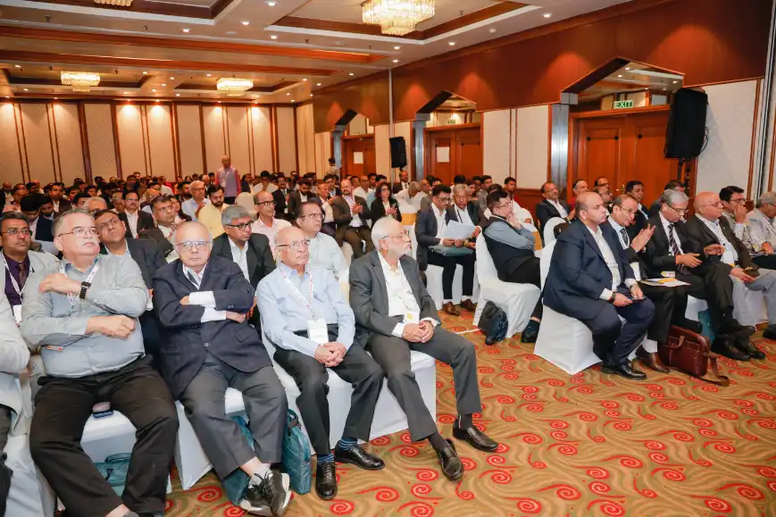 People attending a conference in a large room.