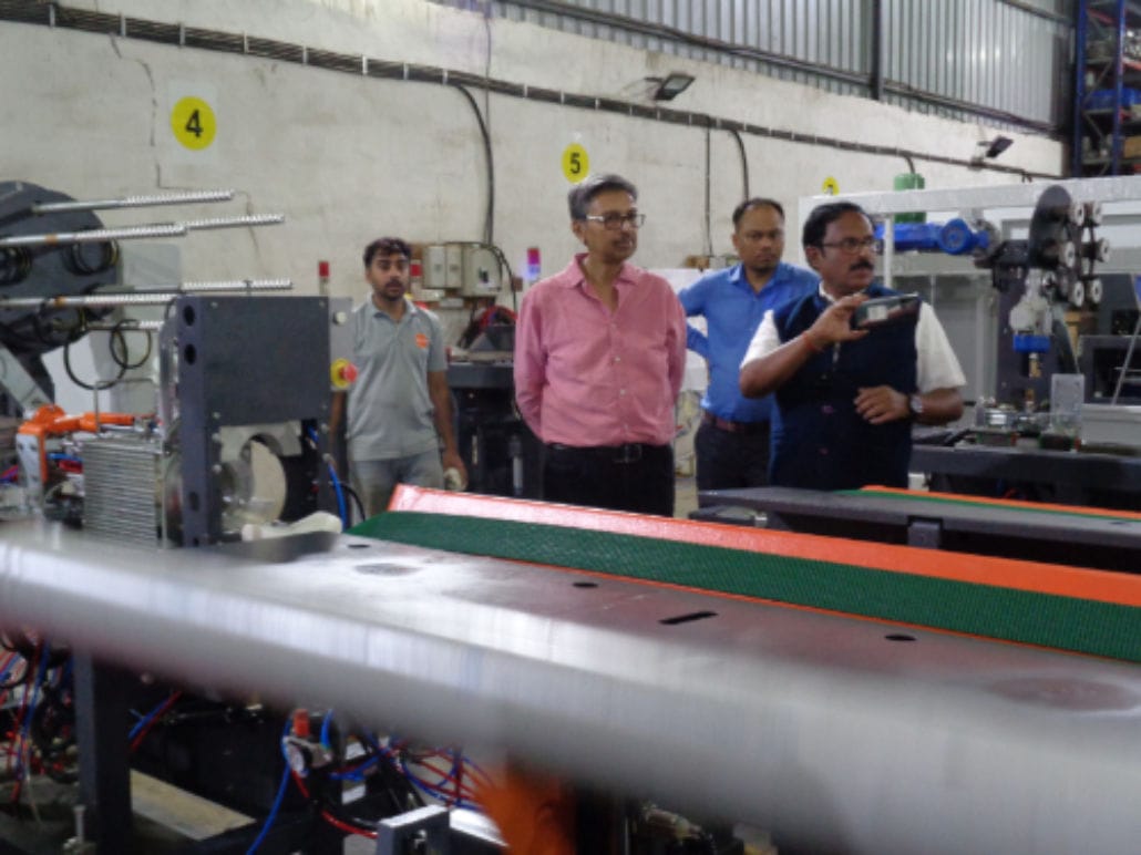 Group of men inspecting factory machinery