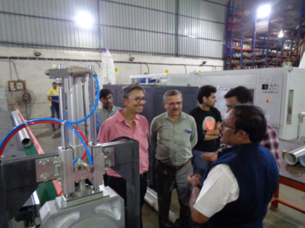 Engineers discussing machinery in a factory setting.