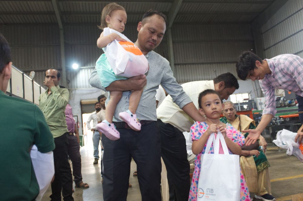 Family receives bags at community event in warehouse.