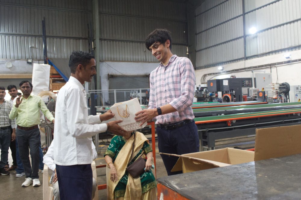 People exchanging gifts in a factory setting.
