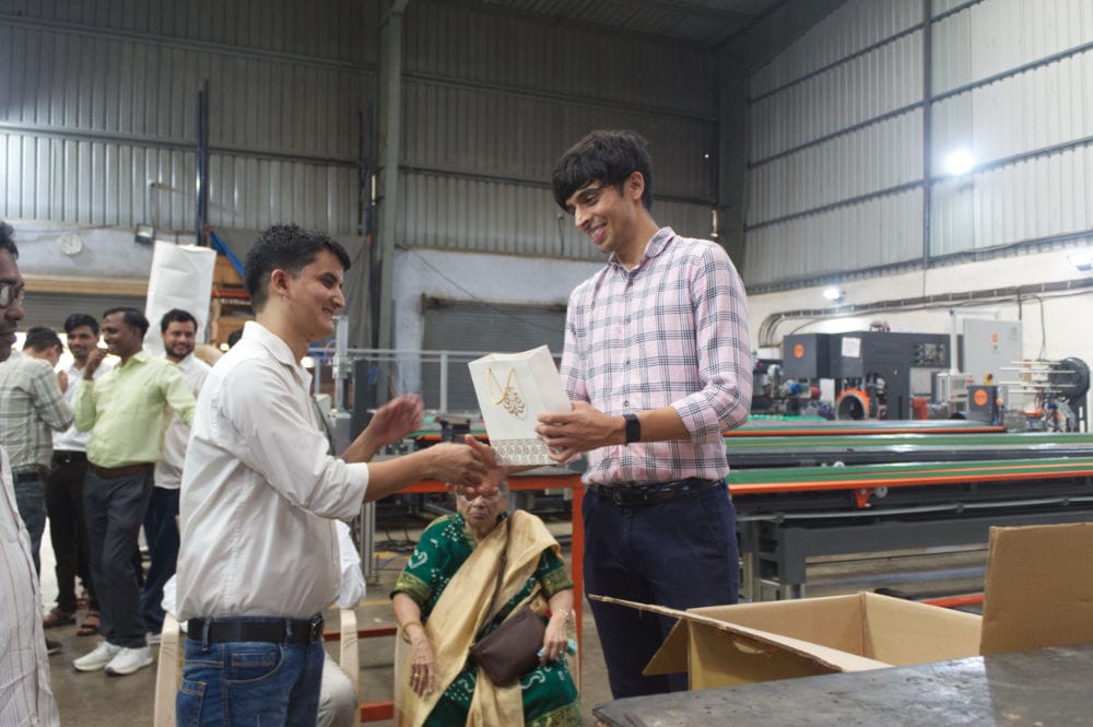 Person receiving a gift in a factory setting.
