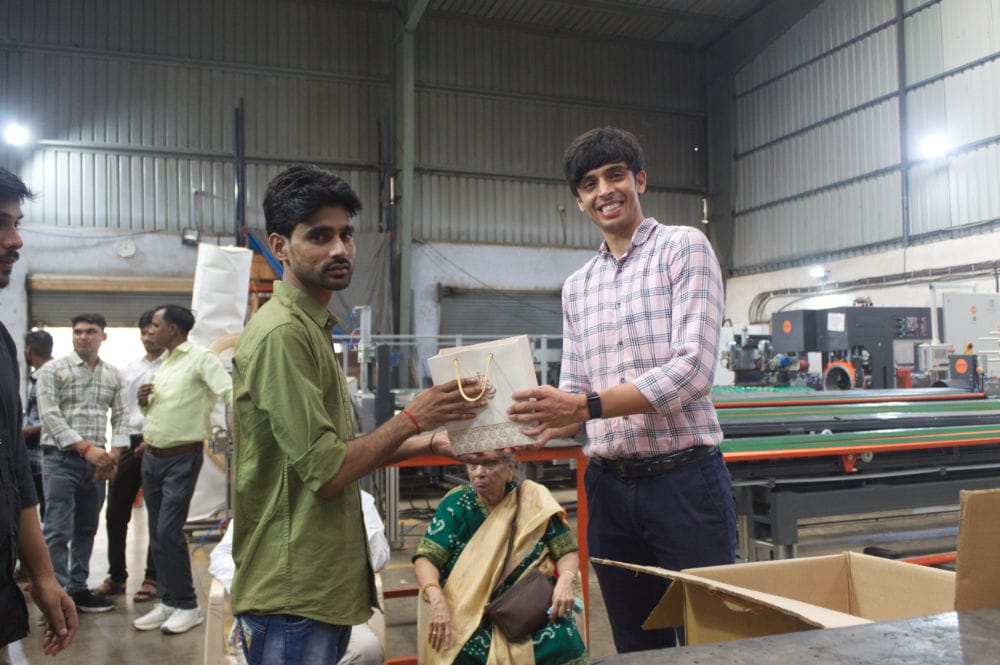 People exchanging gift in industrial setting.