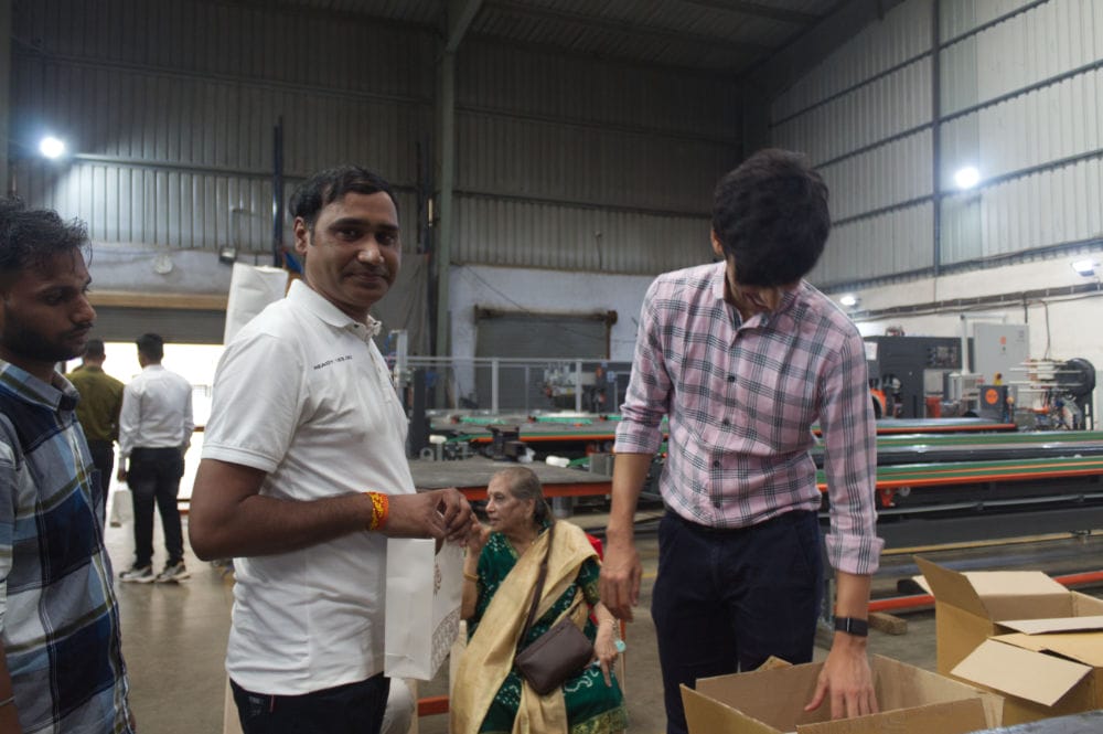People working in a factory setting with machinery.