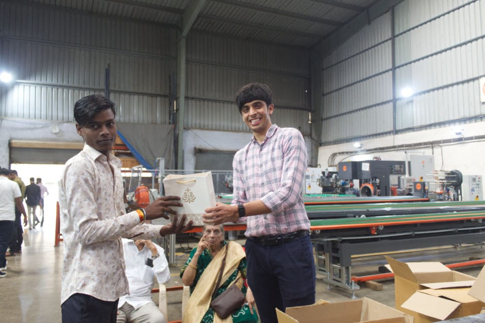 Two men exchanging a gift in a factory.
