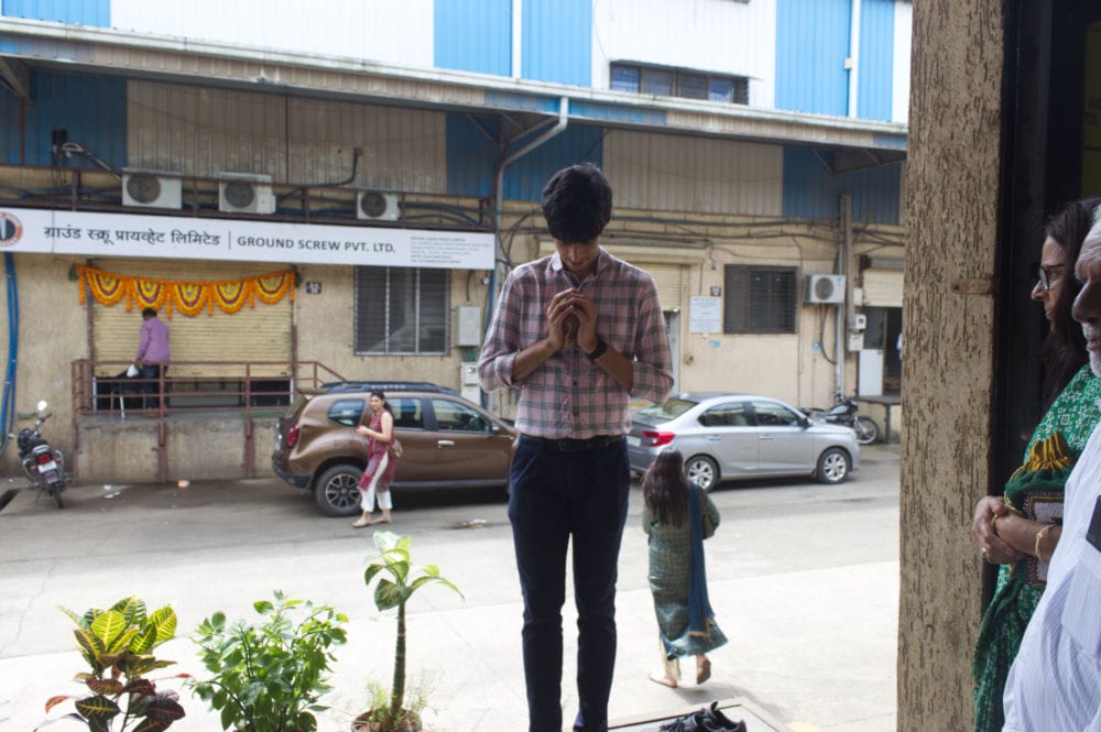 Person folding hands in front of a garage.