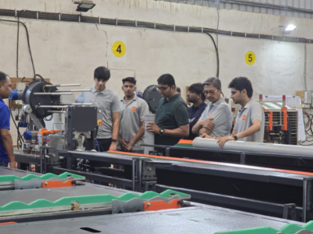 Team inspecting industrial machinery in factory setting.