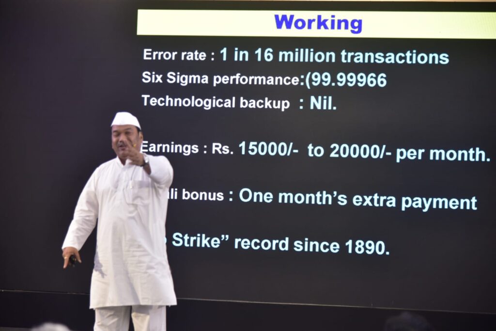 Presenter stands before slide listing work benefits