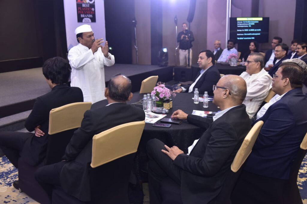 Man in white addressing seated business audience at event