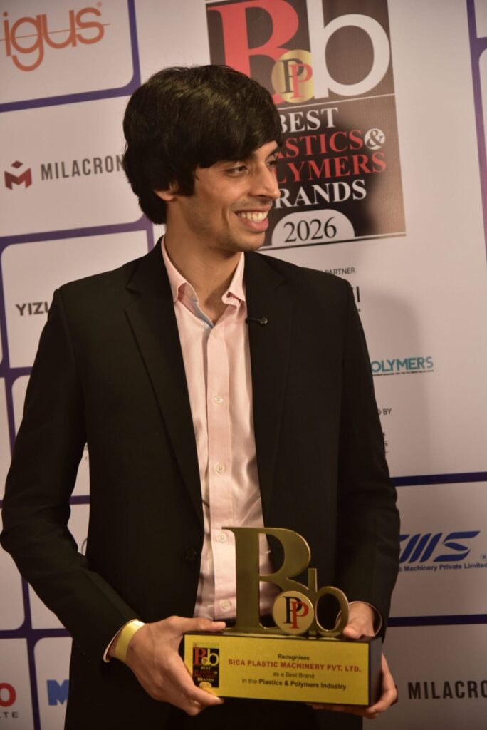 Man holding plastics industry brand award at event