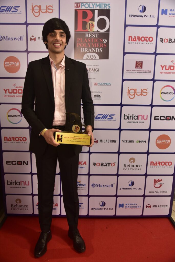 Award recipient holding trophy before ET Polymers sponsor backdrop