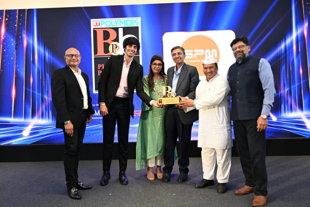 Six attendees present an award at a polymer industry event.