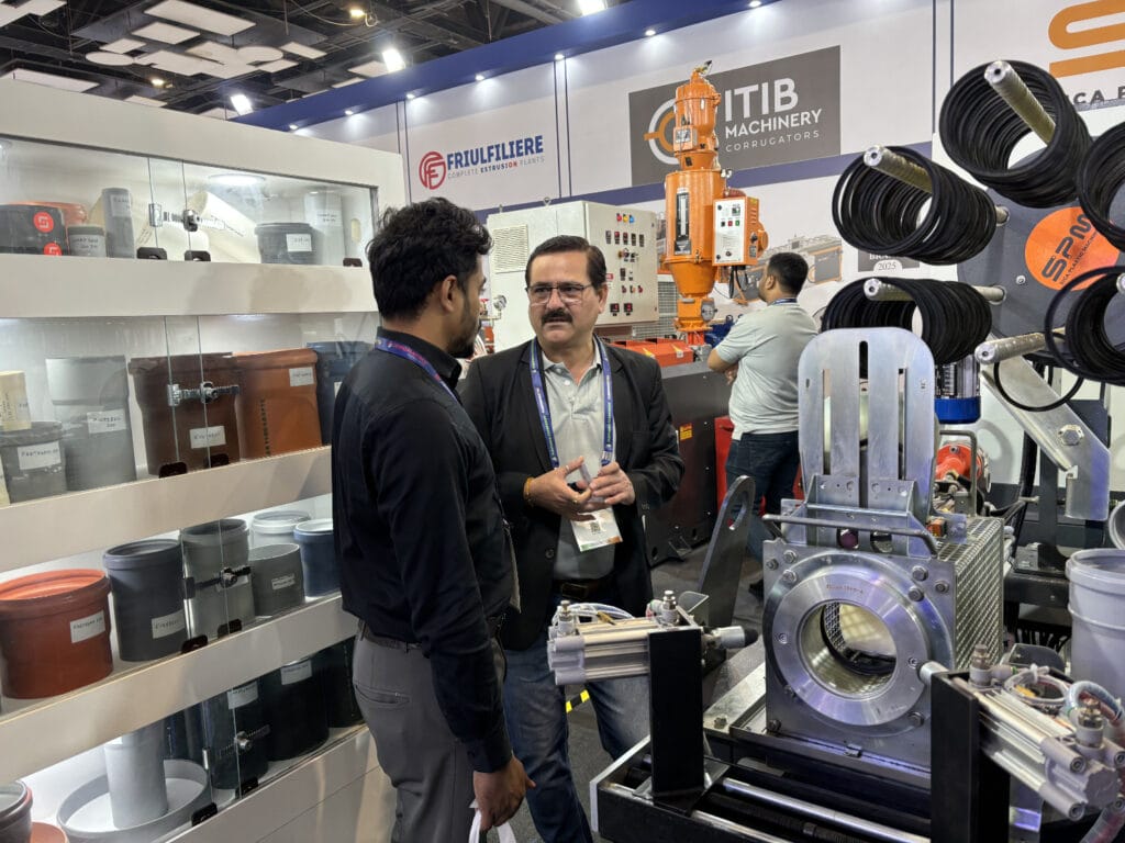 Two men discussing machinery at trade show booth