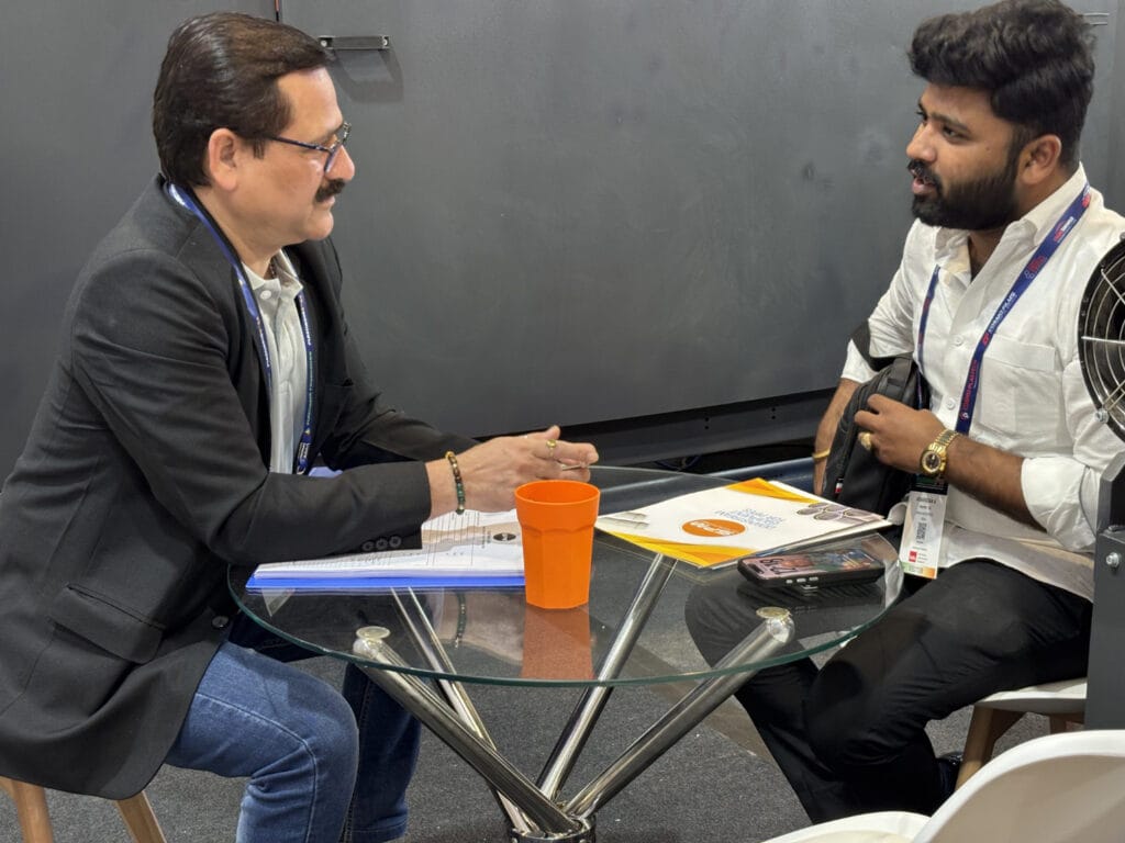 Two men discussing at small glass table
