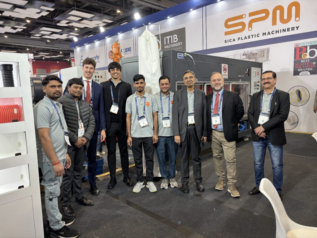 Team posing at plastic machinery trade show booth