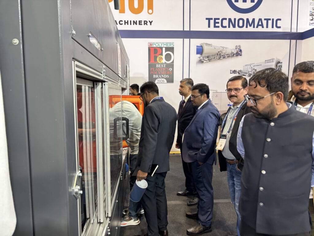 Attendees observing industrial machinery at trade show booth