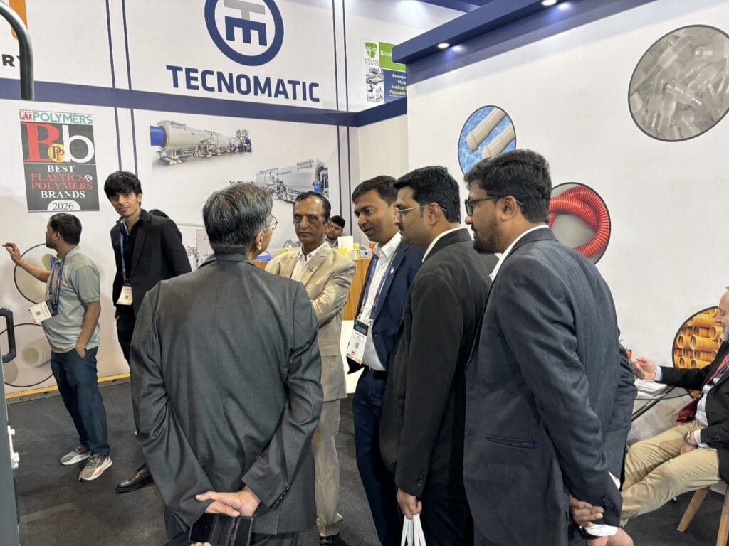 Business professionals networking at Tecnomatic trade show booth