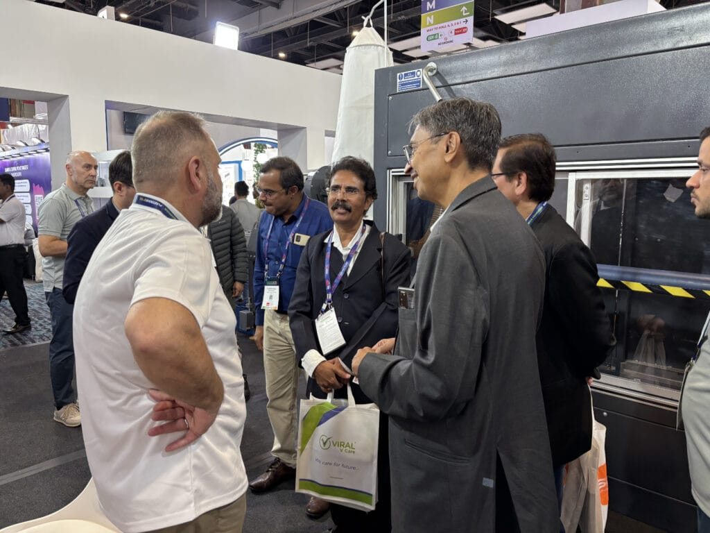 Business professionals discussing equipment at trade show booth