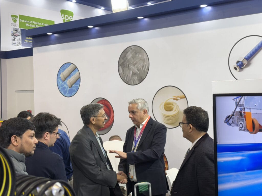 Businessmen shaking hands at medical plastics trade show booth
