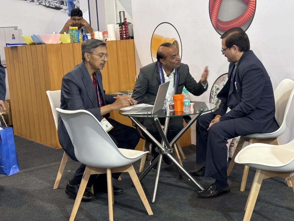 Three businessmen discussing at trade show booth table