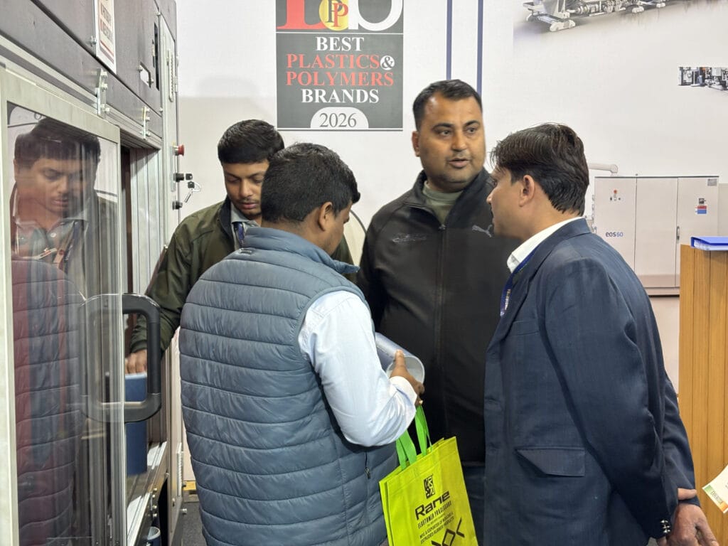 Men discussing machinery at plastics industry booth