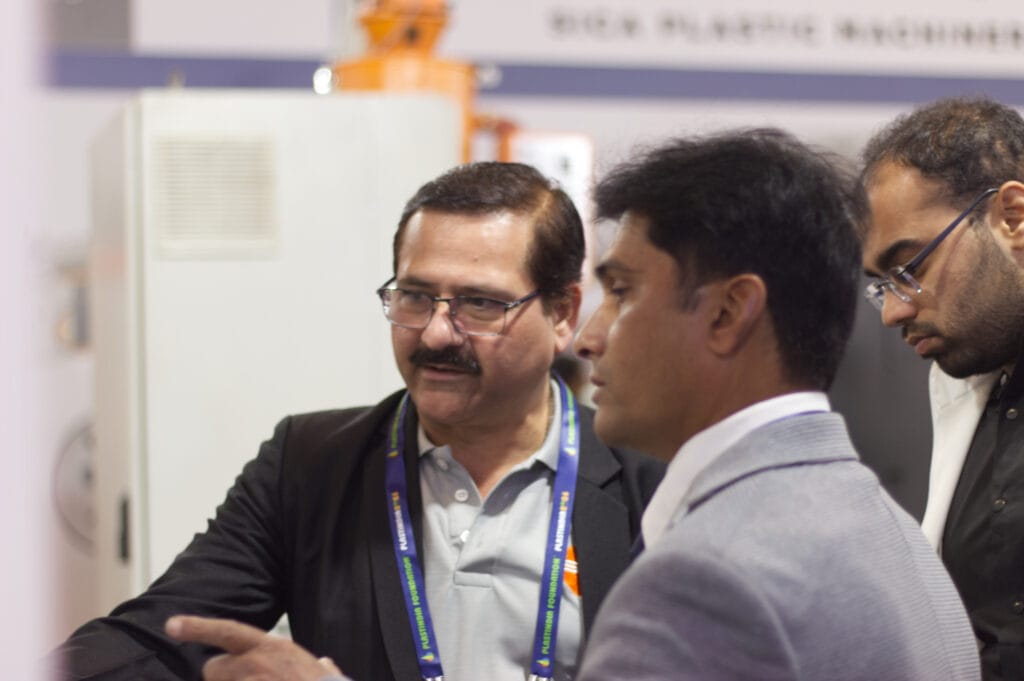 Three businessmen discussing at a trade show booth