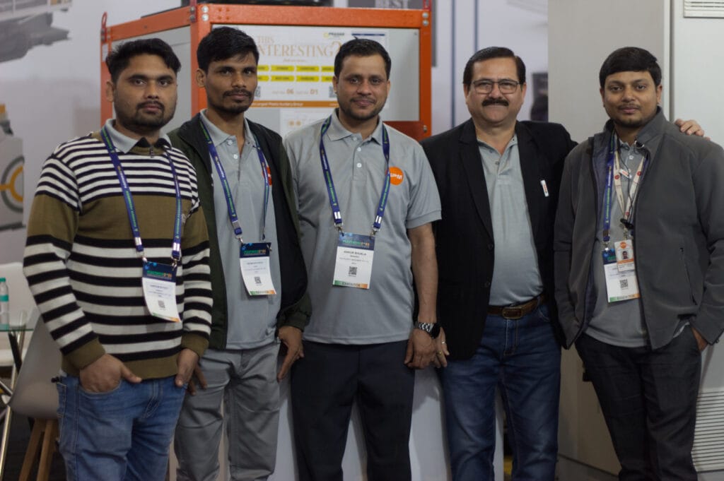 Five men wearing badges at trade show booth