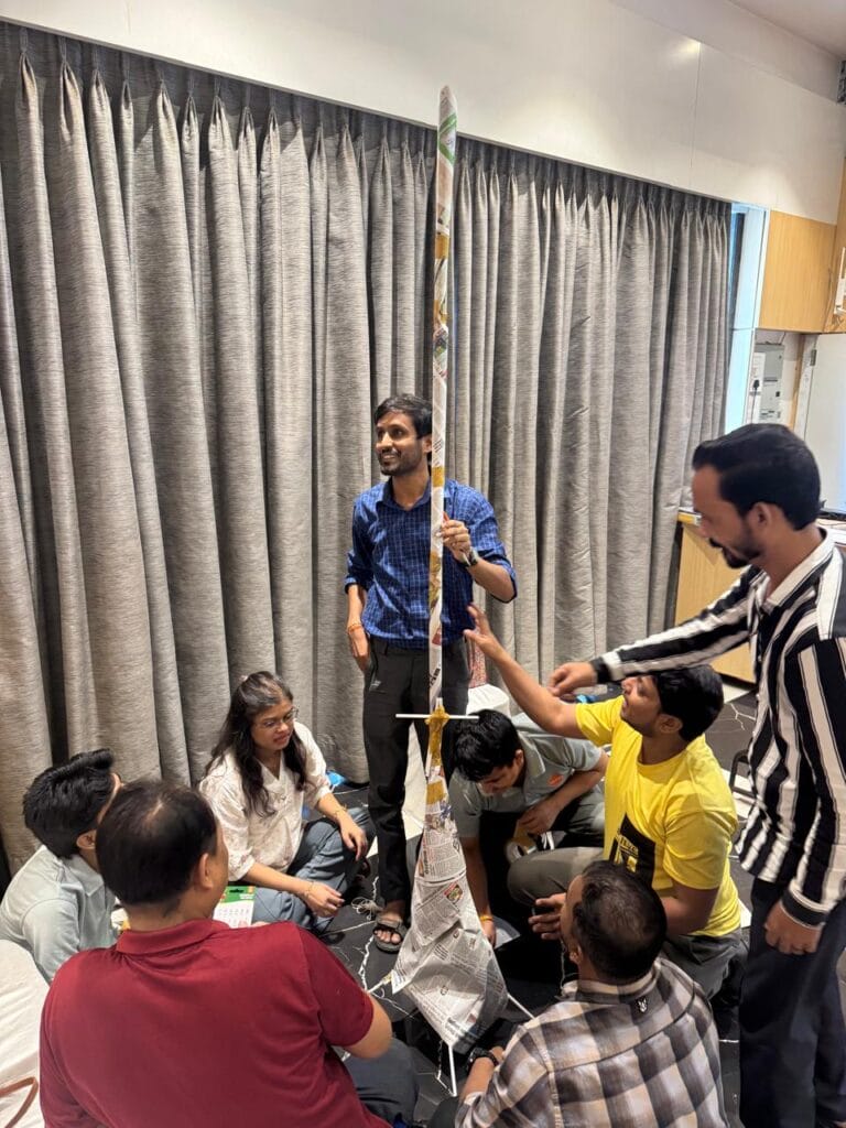 Group builds tall newspaper tower indoors