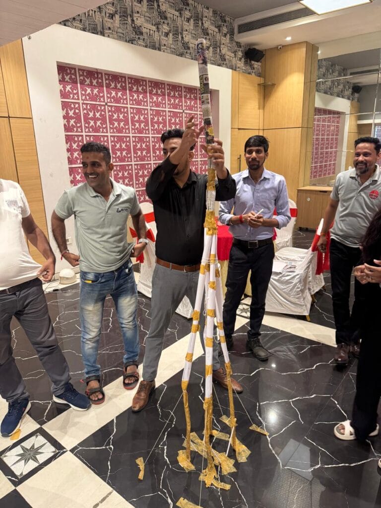 Men display tall gold-and-white ceremonial decoration indoors