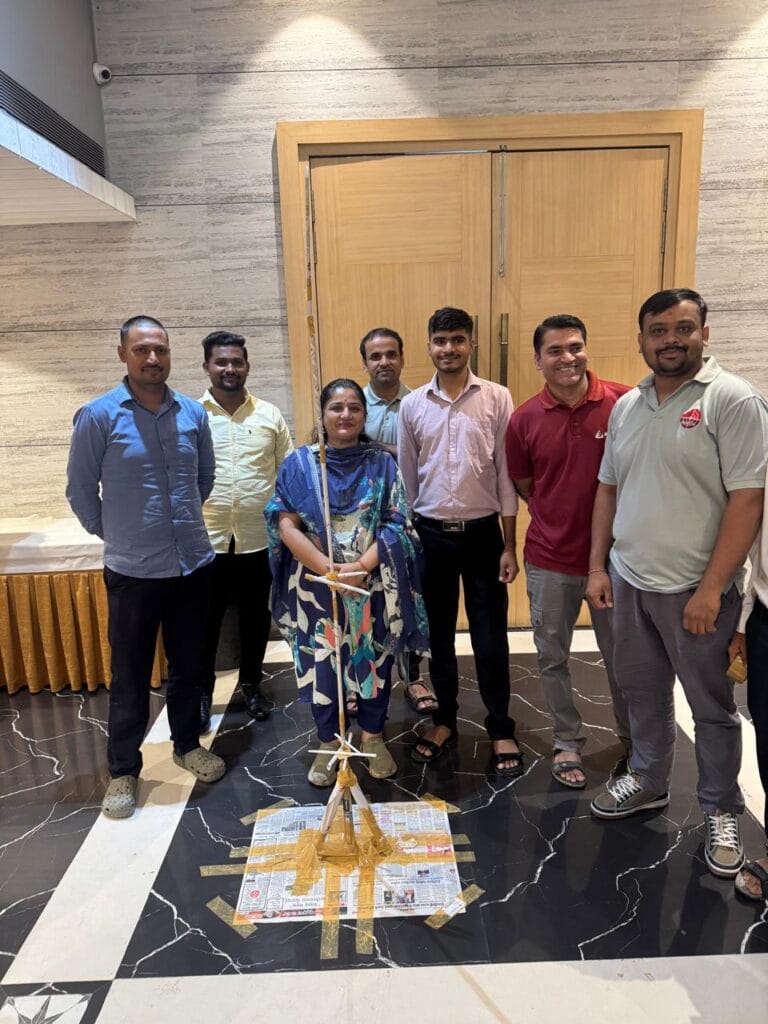 Seven people pose beside a handmade floor display