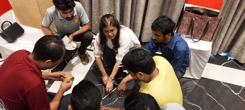 Group collaborating around floor puzzle pieces indoors