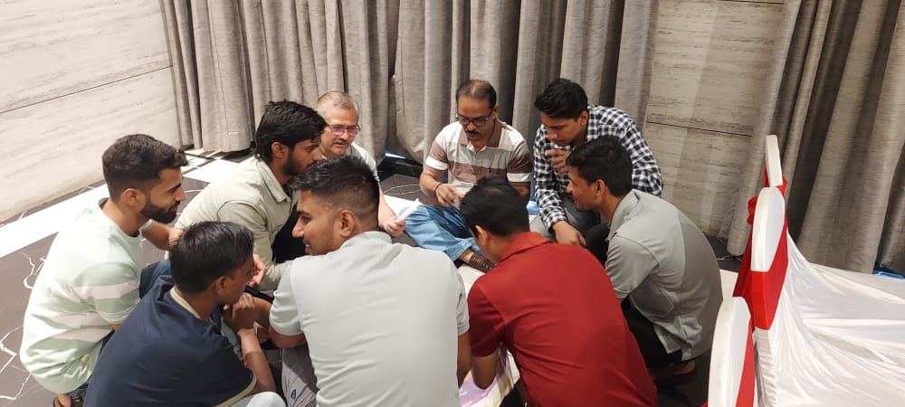 Group of men collaborating while seated on the floor