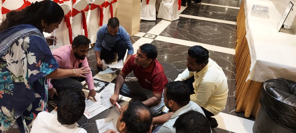 Group organizing papers on a banquet hall floor