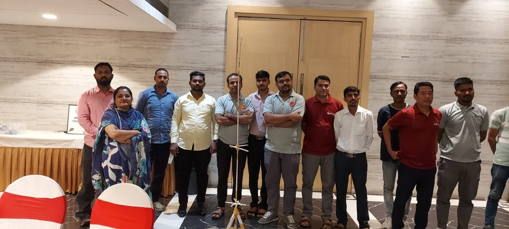 Group of coworkers posing indoors beside a microphone stand