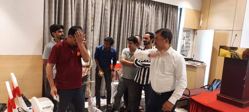 Man gestures beside group at indoor event