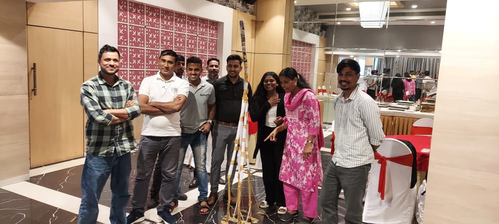 Group posing beside decorated pole at indoor event