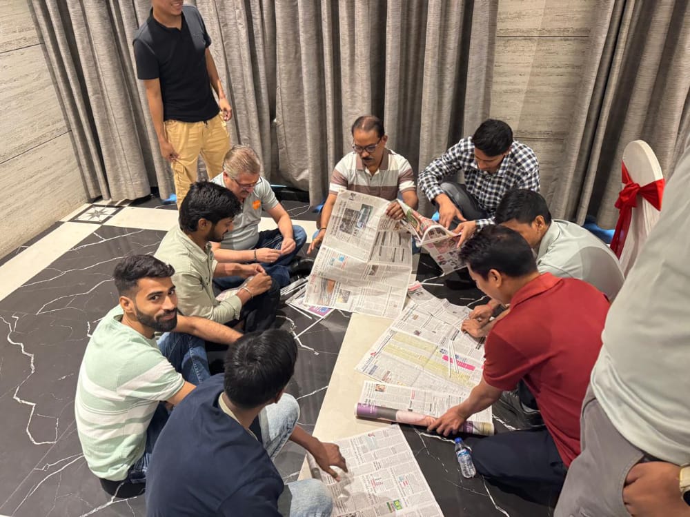 Group of men working with newspapers on floor